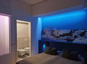 a blue room with a bed and a bathroom at BB La Maratonda in Follonica