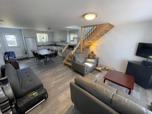 a living room with a couch and a table at Maison sur le lac in Desbiens