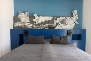 een bed met een blauw en wit hoofdeinde bij B&B La Maratonda in Follonica