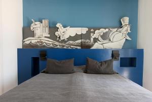 a bed with a blue and white head board at BB La Maratonda in Follonica