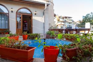 a patio with potted plants and a swimming pool at Хотел Бриз in Kiten