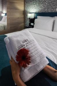 una mujer sosteniendo una toalla encima de una cama en Athens Chic House, en Atenas