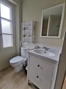 Appartement Escapade Marine - Maison d Aligre في مارانس: حمام ابيض مع مرحاض ومغسلة