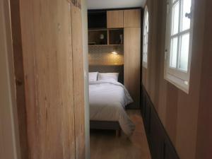 um pequeno quarto com uma cama e uma janela em Appartement Escapade Marine - Maison d Aligre em Marans