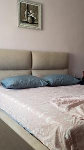 a bed with two blue pillows on top of it at Louis Appartment in Orikum