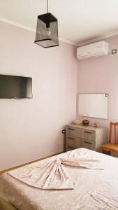 a bedroom with a bed and a white wall at Louis Appartment in Orikum