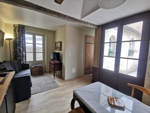 uma sala de estar com um sofá e uma mesa em Appartement Escapade Marine - Maison d Aligre em Marans