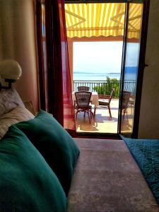 een slaapkamer met een balkon met uitzicht op de oceaan bij Apartments Gabriela in Drvenik