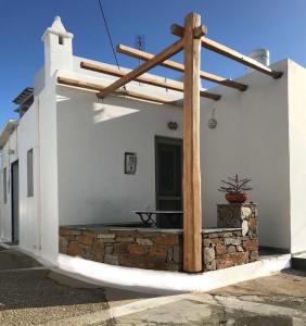 a white building with a wooden pergola on it at Spitaki Serifos Studio in Rámos