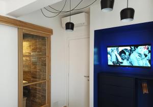 a tv in a room with a blue wall at BB La Maratonda in Follonica