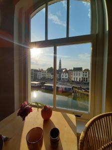 uma janela com uma mesa e vista para um rio em B&B Van Amsterdam em Middelburg