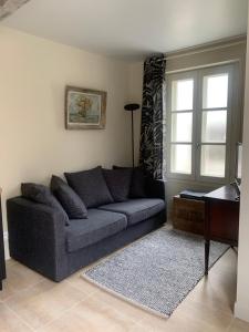 uma sala de estar com um sofá e uma mesa em Appartement Escapade Marine - Maison d Aligre em Marans