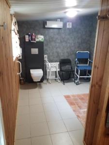 a hospital room with two chairs and a toilet at Gite la petite pataudiere in Le Guédéniau