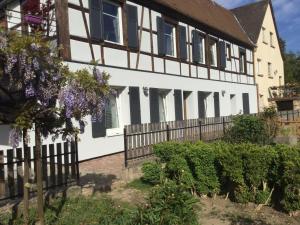 une maison avec une clôture et des fleurs violettes dans l'établissement Gîte côté jardin, à Ingersheim