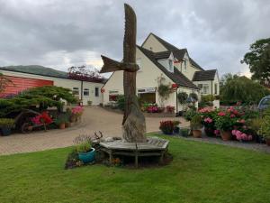 a statue of a bird sitting on a bench in front of a house at LLanwenarth Cottage a beautiful place to just be. in Abergavenny