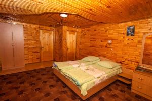 a bedroom with a bed in a wooden cabin at Smerekova Hata in Yablunytsya