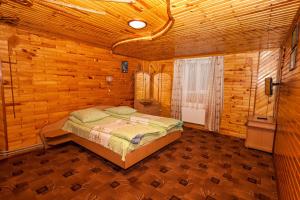 een slaapkamer met een bed in een houten hut bij Smerekova Hata in Yablunytsia