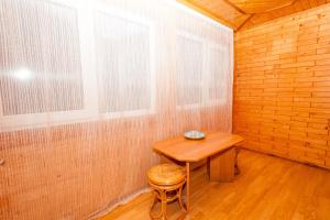 een kleine kamer met een houten tafel en een kruk bij Smerekova Hata in Yablunytsia