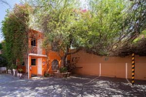 an orange building with a tree in front of it at Hotel Posada Bugambilias in San Luis Potosí