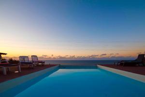 a swimming pool with a view of the ocean at sunset at Dragos del Mar , Espacio Natural in La Orotava