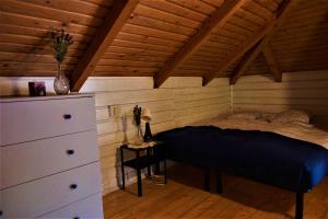 una camera da letto con letto e cassettiera in mansarda di Rudera u Sióstr DREWNIANY DOMEK Stróża a Stróża
