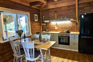 una cucina con tavolo, sedie e un frigorifero nero di Rudera u Sióstr DREWNIANY DOMEK Stróża a Stróża Altre 32 foto