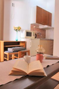 ein offenes Buch auf einem Tisch mit einer Kaffeetasse in der Unterkunft Apartments Gabriela in Drvenik