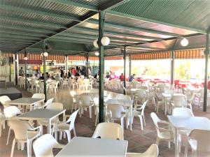 restauracja z białymi stołami i białymi krzesłami w obiekcie Precioso apartamento frente al mar Benalbeach w mieście Benalmádena