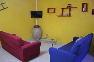 sala de estar con 2 sillas y TV en I Colori della Sicilia, en Valderice