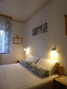 a bedroom with two beds and a window and two lamps at Apartments Milenka in Punat