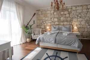 a bedroom with a bed and a stone wall at Captain's Suite in Neusiedl am See