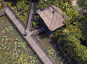 a model of a building with a woman walking on a train track at Hotel Tugu Bali - CHSE Certified in Canggu