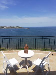 una mesa y sillas en un balcón con vistas al océano en Sea view apartment, en Tsarevo