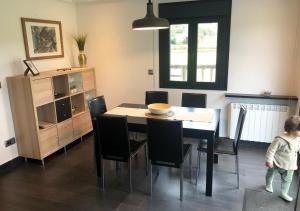 a dining room with a table and black chairs at La Casa de la Ría in Collera