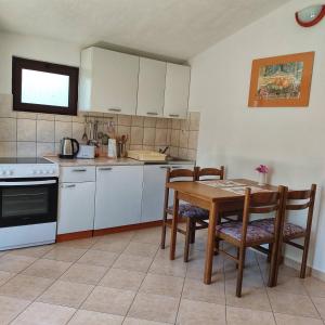 a kitchen with a table and chairs and a table and a stove at Apartment Yadi in Korčula