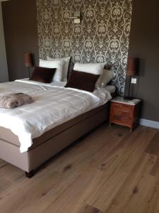 a bedroom with a large bed and a wooden floor at B&B Droomzoet in Herentals