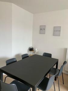 une salle de conférence avec une table et des chaises noires dans l'établissement Nieuwbouwappartement Lippenslaan, 2 -Slaapkamers, à Knokke-Heist