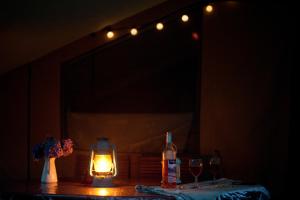 een tafel met een kaars, wijnglazen en een spiegel bij Tente Lodge La Téouleyre in Saint-Julien-en-Born