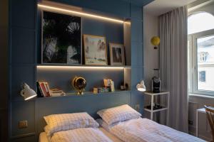 a bedroom with blue walls and a bed with two pillows at Hôtel et Spa La Villa K - Basel Airport in Saint-Louis