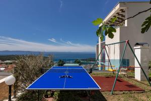 a blue ping pong table in a backyard with a view at Villa Afrodita in Makarska