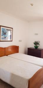 a bedroom with a large bed with a wooden headboard at Praia Oura Sunset in Albufeira