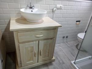 y baño con lavamanos de madera. en Albergue la Medina de Camponaraya, en Camponaraya