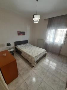 een slaapkamer met een bed, een tafel en een raam bij Asteris appartment in Thérmi