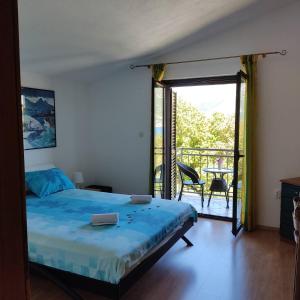 a bedroom with a bed and a balcony with a view at Apartment Yadi in Korčula