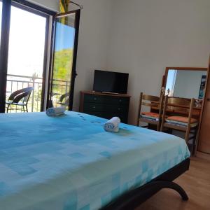 a bedroom with a blue bed and a balcony at Apartment Yadi in Korčula