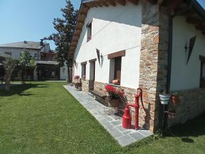 a white house with a red fire hydrant next to it at Albergue la Medina de Camponaraya in Camponaraya