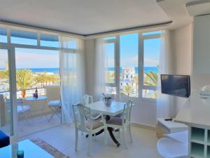 a living room with a table and a view of the ocean at FANTASTIC APARTMENT B IN FRONT OF THE SEA & MARINA in Estepona