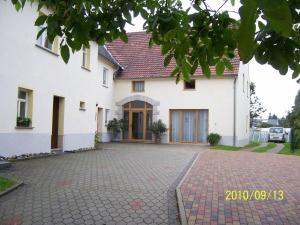 a white house with a driveway in front of it at Pension Annelie in Schullwitz