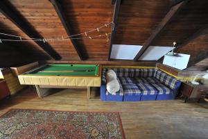 Zimmer mit Sofa und Billardtisch in der Unterkunft Nostalgija Pervalkoje in Neringa