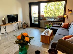 ein Wohnzimmer mit Sofa und Fernseher in der Unterkunft Luchsbutze in Sankt Andreasberg